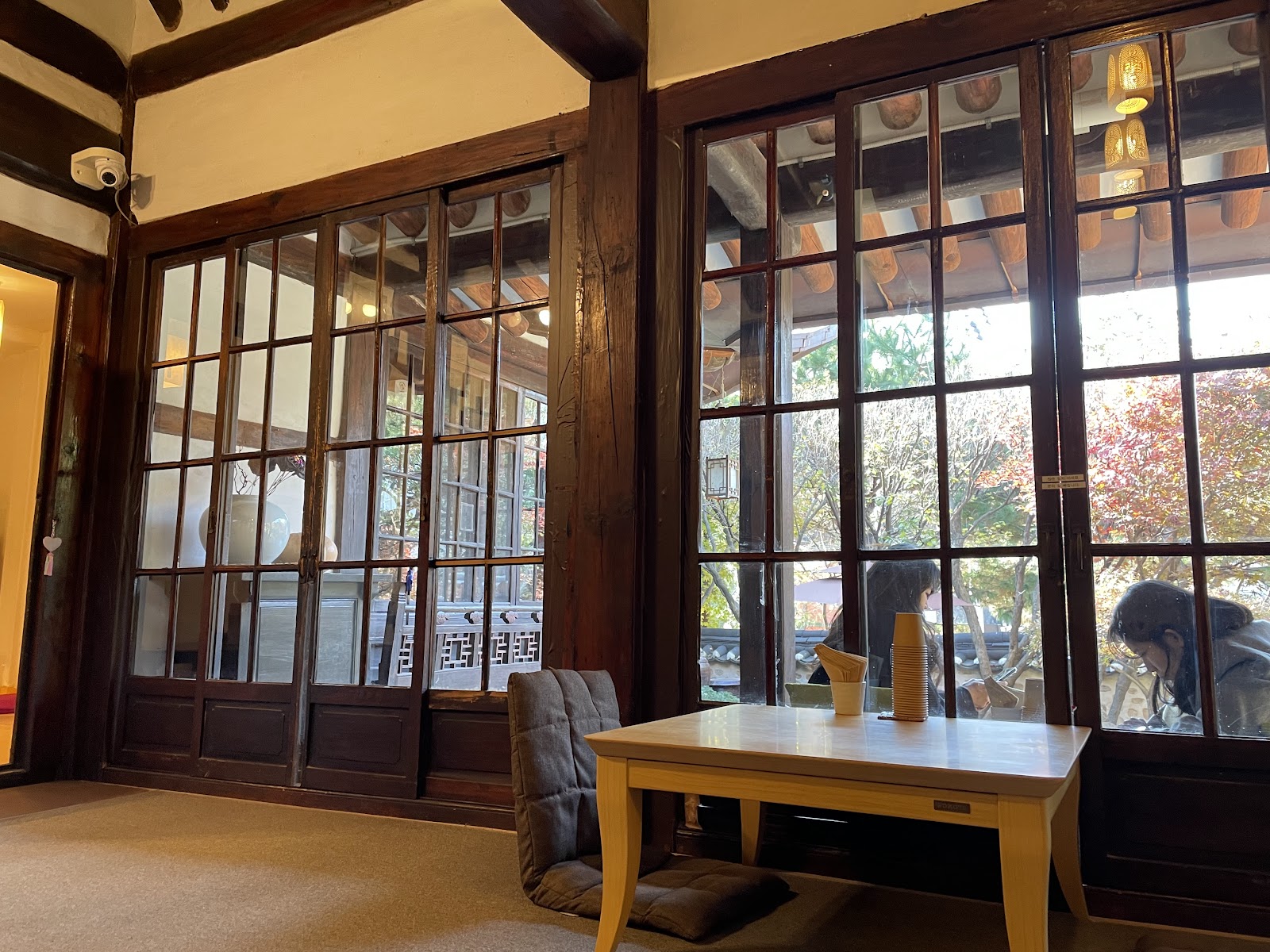 Traditional wooden interior of Suyeonsanbang with floor-to-ceiling glass panels overlooking the courtyard garden